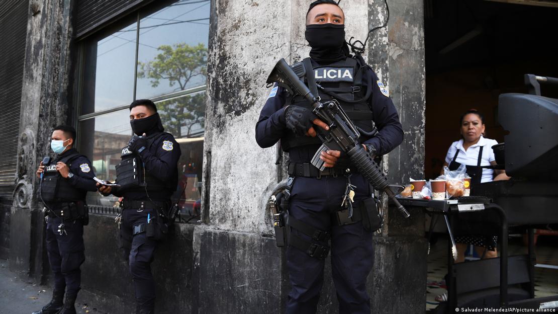 Policiais armados diante de um café 