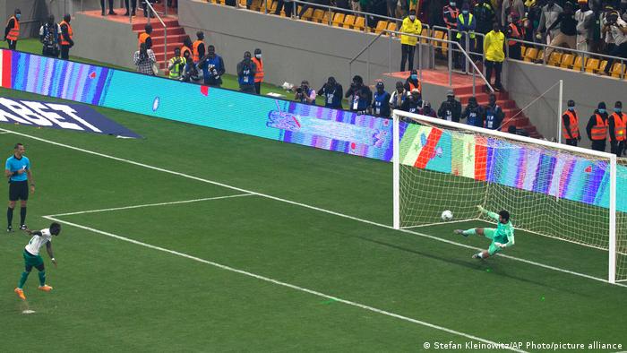 Sadio Mané raakt de bal in de linkerhoek tijdens een strafschoppenserie in de WK-kwalificatiewedstrijd tegen Egypte, Egypte-doelman springt de andere kant op.