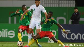 Le milieu algérien Sofiane Feghouli (centre) avec les joueurs camerounais Karl Toko Ekambi et Collins Fai lors du barrage pour la qualification au mondial 2022