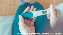 Middle age woman hand is holding pregnancy test, result is pregnant, ?Schwanger? || Modellfreigabe vorhanden