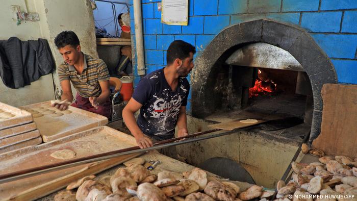 Workers prepare bread at a bakery