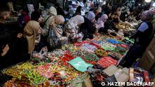 Palestinians shop for sweets amidst preparations before the start of the Muslim holy fasting month of Ramadan in the old city of Jerusalem on March 28, 2022. (Photo by HAZEM BADER / AFP)