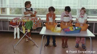 Children wash clothes and hang them on a clothes horse at a kindergarten in Eisenach in 1976