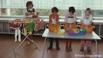 Children wash clothes and hang them on a clothes horse at a kindergarten in Eisenach in 1976