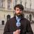 DW reporter Amien Essif stands in a square in Lviv, Ukraine and holds a DW microphone