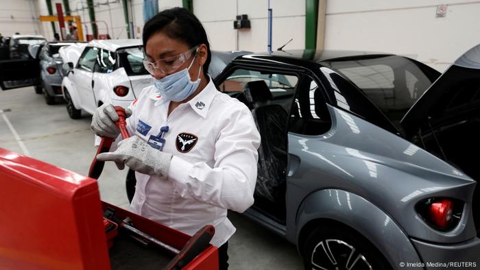 A women works on a car at the assembly line of the Zacua auto plant, Mexico's first electric car brand built mainly by women, in Puebla, Mexico