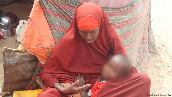A Somali woman holds her son inside an IDP camp