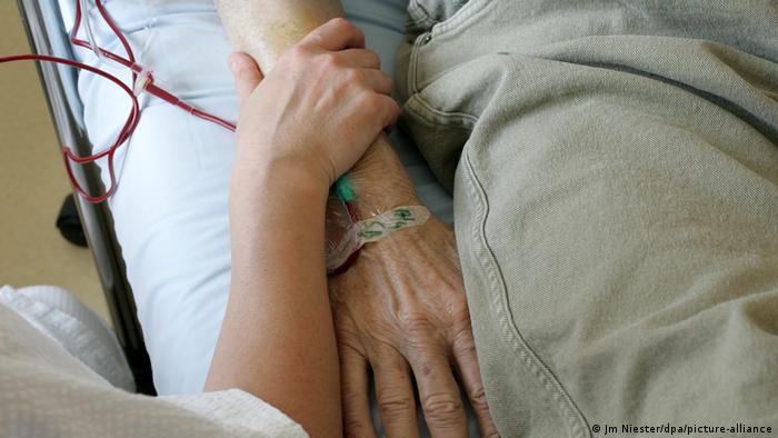 Nurse holding man's hand