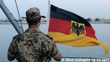 DJIBOUTI - JUNE 23: A German soldier participating in the international ATALANTA anti-pirate campaign lowers the German flag on board the German naval frigate Schleswig-Holstein during the visit of German Defense Minister Karl-Theodor zu Guttenberg on June 23, 2010 in Djibouti port, Djibouti. The Schleswig-Holstein is among international naval vessels that patrol and escort ships through the Gulf of Aden and off the coast of Somalia. Zu Guttenberg will also visit German troops based in Cyprus for the UNIFIL peace-keeping mission. (Photo by Sean Gallup/Getty Images)