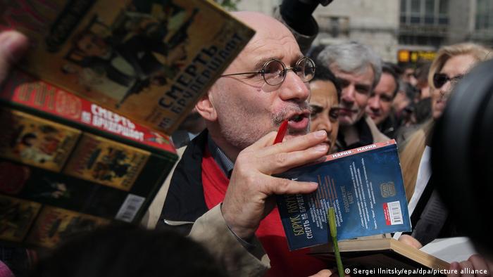 Author Boris Akunin signs books as a crowd of people surround him
