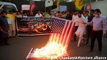 Pakistani Shiite Muslims and supporters of ruling party Pakistan Tehreek-e-Insaf burn a representation of U.S flag during an anti U.S protest, outside U.S consulate in Lahore, Pakistan, Friday, April 1, 2022. In an address to the nation on Thursday Pakistani Prime Minister Imran Khan lashed out at the United States, claiming Washington had conspired with the Pakistani opposition against him. (AP Photo/K.M. Chaudary)