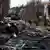 Soldiers walk past a destroyed Russian tank and armored vehicles in Bucha, Ukraine