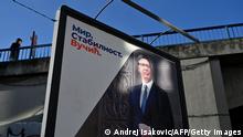 A man walks past a pre-election billboard depicting Serbian President Aleksandar Vucic and the cyrillic writing reading Peace. Stability. Vucic in Belgrade on April 2, 2022, day ahead of the general and presidential elections in Serbia. - With another election victory in his sights, Serbia's populist President Aleksandar Vucic looks set to extend his rule over the Balkan nation after a decade of tightening his grip over the levers of power. (Photo by Andrej ISAKOVIC / AFP) (Photo by ANDREJ ISAKOVIC/AFP via Getty Images)