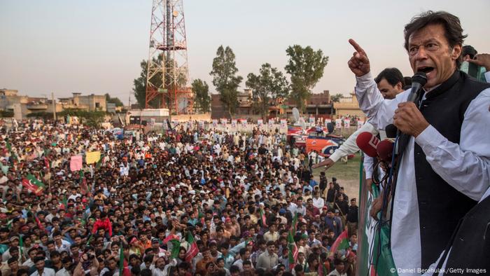 Imran Khan speaks into a microphone at a 2013 rally