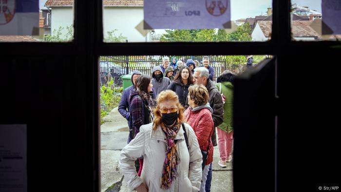 Menschen stehen vor einem Wahllokal an