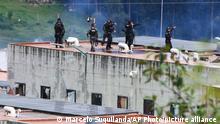 Police take positions on the roof of Turi prison after a deadly prison riot in Cuenca, Ecuador, Sunday, April 3, 2022. (AP Photo/Marcelo Suquilanda)