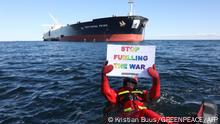 This Handout photo made available by Greenpeace shows one of their activists holding an anti-war placard as they float in the water in front of the supertanker Pertamina Prime off the coast of Denmark on March 31, 2022, blocking the transshipment of a Russian oil shipment between two ships. (Photo by Kristian Buus / GREENPEACE / AFP) / RESTRICTED TO EDITORIAL USE - MANDATORY CREDIT AFP PHOTO / GREENPEACE / KRISTIAN BUUS - NO MARKETING - NO ADVERTISING CAMPAIGNS - DISTRIBUTED AS A SERVICE TO CLIENTS