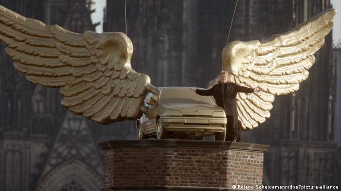Златният Форд Фиеста с ангелски криле пред Кьолнската катедрала е дело на художника Х.А. Шулт и символизира една отминала епоха: според автора колата вече е изгубила култовия си ореол. Едни са склонни да видят в арт инсталацията края на автомобилната епоха, а други - скрита реклама на Форд.