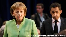 FILE - Former German Chancellor Angela Merkel, left, and former French President Nicolas Sarkozy, right, walk to their seats during a session with invitees, at the NATO Summit conference in Bucharest, Romania, April 3, 2008. Angela Merkel's office says the former German chancellor stands by decisions in 2008 not to put Ukraine directly on track to join NATO. (AP Photo/Gerald Herbert, File)