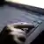 Рука натискає кнопку на клавіатурі (фотоілюстрація)
