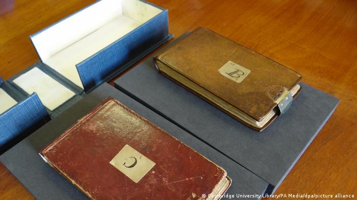Zwei in Leder eingebundene Notizbücher liegen auf einem Tisch.