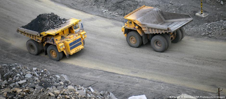 A loaded dump truck passes an empty truck as it carries away coal at the Kedrovsky open-pit coal mine in Kemerovo, Russia, Tuesday, June 16, 2015.