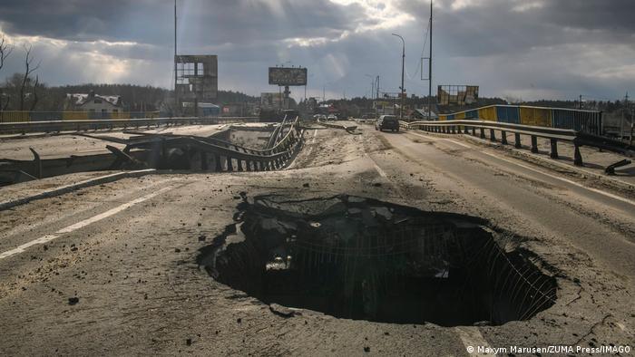 A gaping hole from an artillery shell in a now deformed bridge in Bucha, Ukraine