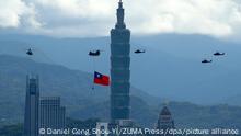 07.10.2021, Taipeh - Ein Militärhubschrauber zieht eine riesige Taiwan-Fahne hinter sich her und fliegt vor den Feierlichkeiten des Nationalfeiertag am Hochhaus «Taipei 101» vorbei. Die militärischen Bedrohungen von China nehmen zu. China hat eine Rekordzahl ihrer Militärjets in Taiwans Identifikationszone für die Luftverteidigung (ADIZ) geschickt, während das Land bessere Beziehungen zu den USA, Australien, Japan und weiteren europäischen Ländern, wie Litauen, Polen und der Tschechischen Republik, aufbaut. +++ dpa-Bildfunk +++