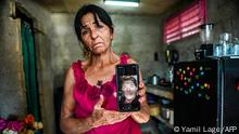 Virgen Frometa, sister of Germany-based Cuban national Luis Frometa, sentenced to 25 years in prison for his participation in recent anti-government protests, shows a picture of her brother in the La Guinera neighbourhood of Havana, on March 29, 2022. - Relatives of protesters sentenced for sedition and theft in Cuba are calling for fair sentences after the Supreme Court sentenced 128 demonstrators to six to 30 years in prison. The group of those sentenced corresponds to the demonstrations in La Guinera and Diez de Octubre municipalities, two of the most violent protests of July 11 and 12 in Cuba. (Photo by YAMIL LAGE / AFP)