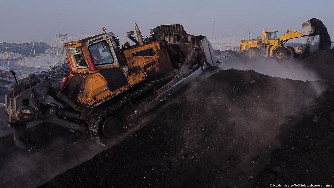 Máquinas trabalham em meio a uma mina de carvão na Rússia.