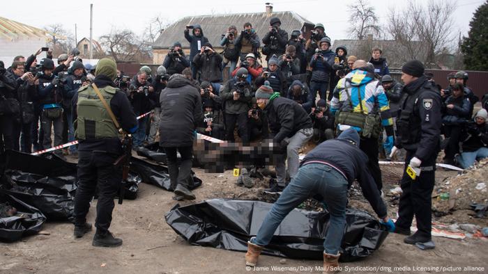 Ukraine, Butscha: Reporter filmen und fotografieren, wie Leichen in Säcke gehüllt werden