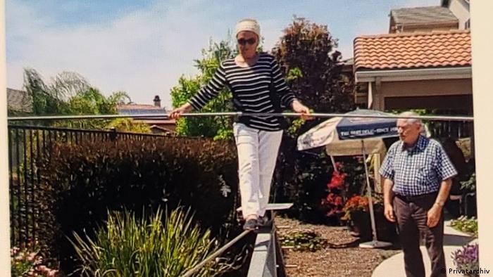 Frieda Daniels, wearing sungalsses, walking a low tightrope in her Californian garden