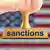 Печать з написом англійською "санкції" на тлі прапору США