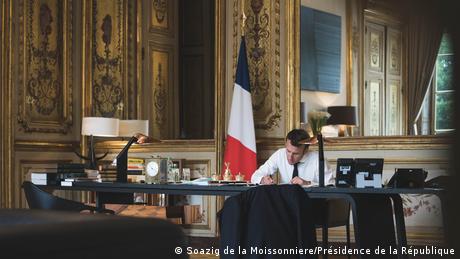 Emmanuel Macron sentado en su escritorio, diseñado por Thierry Lemaire.