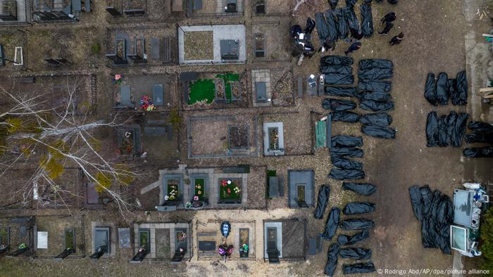 Luftbild des Friedhofs in Butscha: Neben Gräbern liegen schwarze Leichensäcke