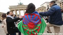 BERLIN, GERMANY - APRIL 08: A participant dances with a Romani flag at a pro-Romani demonstration in front of the Brandenburg Gate on International Romani Day on April 8, 2015 in Berlin, Germany. The annual event was created in London in 1971 to raise awareness of the issues facing Romani people and to celebrate the ethnic minority's culture. According to government figures, the majority of the estimated 70,000 Romani in Germany are Sinti, a subgroup that along with Roma were among those specifically targeted for genocide during the country's Nazi period. An estimated 10-12 million Romani live in Europe today, according to the European Commission. The Romani arrived in Germany 600 years ago, but as in other countries still face a form of discrimination known as antiziganism, or anti-Romanyism, to this day, forcing some to hide their ancestry. (Photo by Adam Berry/Getty Images)