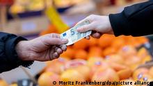 Ein Kunde bezahlt seinen Einkauf an einem Stand auf einem Wochenmarkt mit einem Fünf-Euro-Schein (gestellte Szene). Nach dem Preisschub im Jahr 2021 hoffen Verbraucher in Deutschland auf Entspannung bei der Teuerung. Wie sich die Inflation im Januar 2022 entwickelt hat, gibt das Statistische Bundesamt am Nachmittag (31.01.2022) in einer ersten Schätzung bekannt. Im Dezember 2021 waren die Verbraucherpreise gegenüber dem Vorjahresmonat um 5,3 Prozent gestiegen.