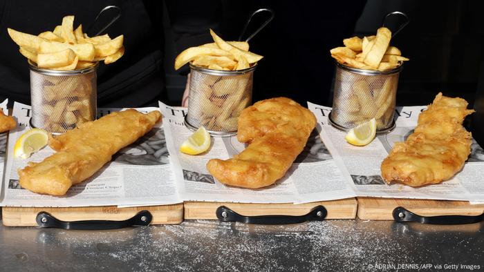 Three portions of fish and chips neatly arranged on newspaper, side by side. (Photo by ADRIAN DENNIS / AFP) (Photo by ADRIAN DENNIS/AFP via Getty Images)