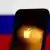 Экран айфона с логотипом Apple на фоне флага РФ