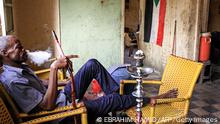 A man smokes a waterpipe (also known as shisha or hookah) at a cafe in the Sudanese capital Khartoum on August 22, 2019. - Sudan's democratic transition is barely starting but many young people are wasting no time in using the new space this regime change created to exercise personal freedoms. Under ousted ruler Omar al-Bashir, curbs on sartorial freedom were also harsh on women, with security often adopting a hardline interpretation of the penal code that banned indecent outfits. Women have been sentenced to lashes for wearing trousers on many occasions, in line with the Sharia law Bashir imposed after taking power in a 1989 coup. (Photo by Ebrahim HAMID / AFP) (Photo credit should read EBRAHIM HAMID/AFP via Getty Images)
