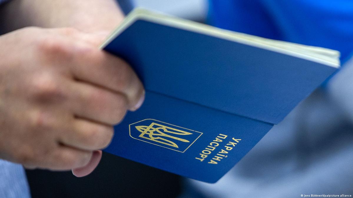 Eine Hand mit einem ukrainischen Pass