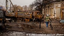 April 2, 2022, Trostyanets, Sumy, Ukraine: A woman walks her bike around destroyed Russian vehicles at Trostyanets, Ukraine on April 2, 2022. Russian troops held the city but have since been pushed back by Ukrainian forces. (Credit Image: © Daniel Carde/ZUMA Press Wire