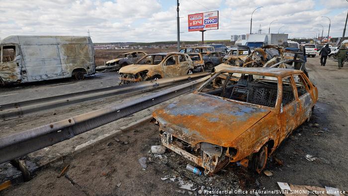 Ukraine-Krieg Butscha | Ausgebrannte und zerschossene PKws auf einer zweispurigen Landstraße