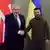 Volodimir Zelenski e Boris Johnson apertam as mãos em frente às bandeiras de seus países