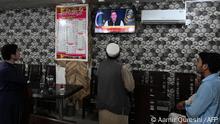 People listen to Pakistan's Prime Minister Imran Khan addressing the nation on television at a restaurant in Islamabad on April 8, 2022. - Pakistan Prime Minister Imran Khan is to address the nation on march 8, 2022, on the eve of a controversial no-confidence vote that looks certain to dismiss him. (Photo by Aamir QURESHI / AFP)