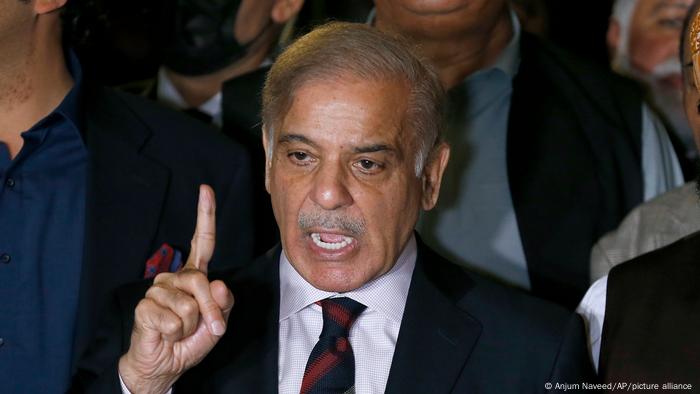 Shehbaz Sharif with his pointer finger raised and a tie