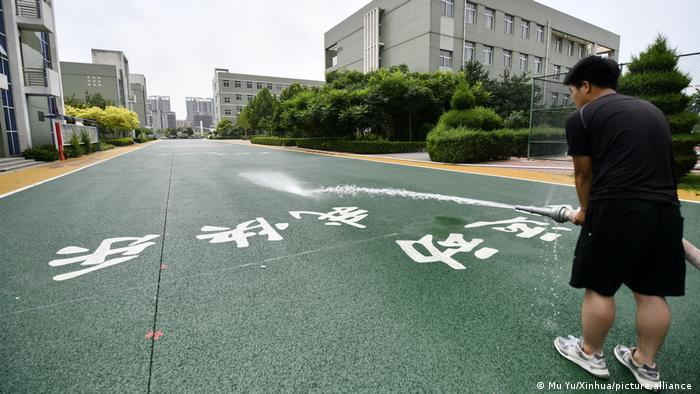 A staff member tests the function of permeable surface of a road in a primary school in Qian'an City of north China's Hebei Province