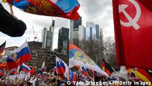 A Soviet flag (R) is seen as people take part in a pro-Russian demonstration in Frankfurt am Main, western Germany, on April 10, 2022, amid the war in Ukraine. (Photo by Yann Schreiber / AFP) (Photo by YANN SCHREIBER/AFP via Getty Images)