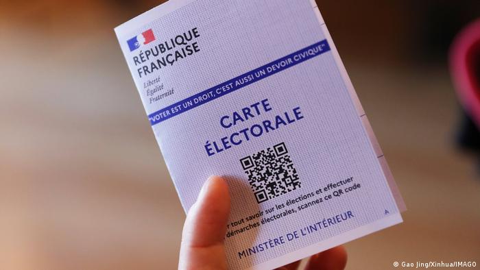 A hand holds up an electoral card
