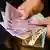 Женщина держит банкноты в 5, 10, 20 и 50 гривен